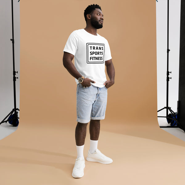 Man modelling a white "Trans Sports Fitness" t-shirt, standing confidently in a photo studio with hands in pockets